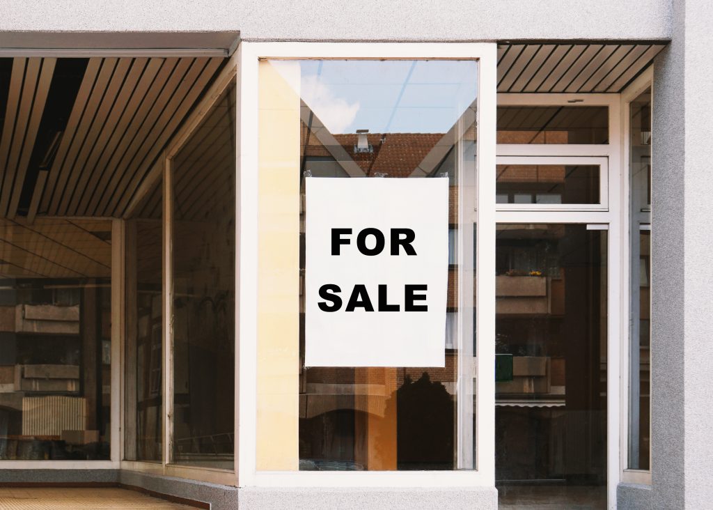When the Deal Dies: Specific Performance, Damages, and Interest Traps in Commercial Real Estate for sale sign in store window